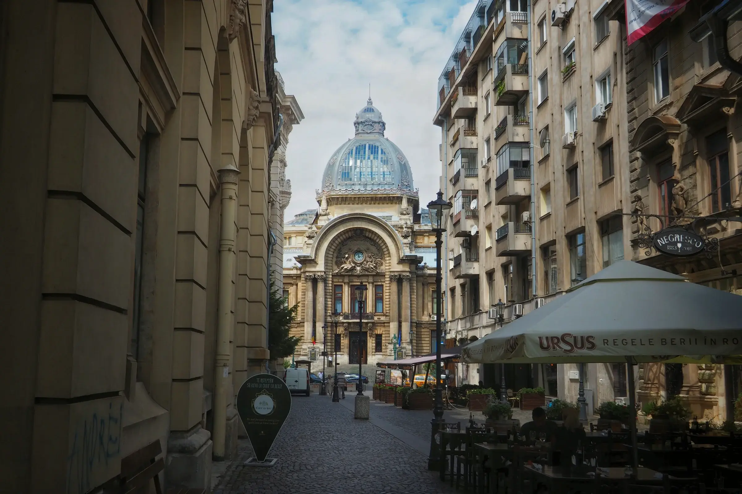 Le dôme de verre du palais CEC au bout d’une rue pavée de Bucarest